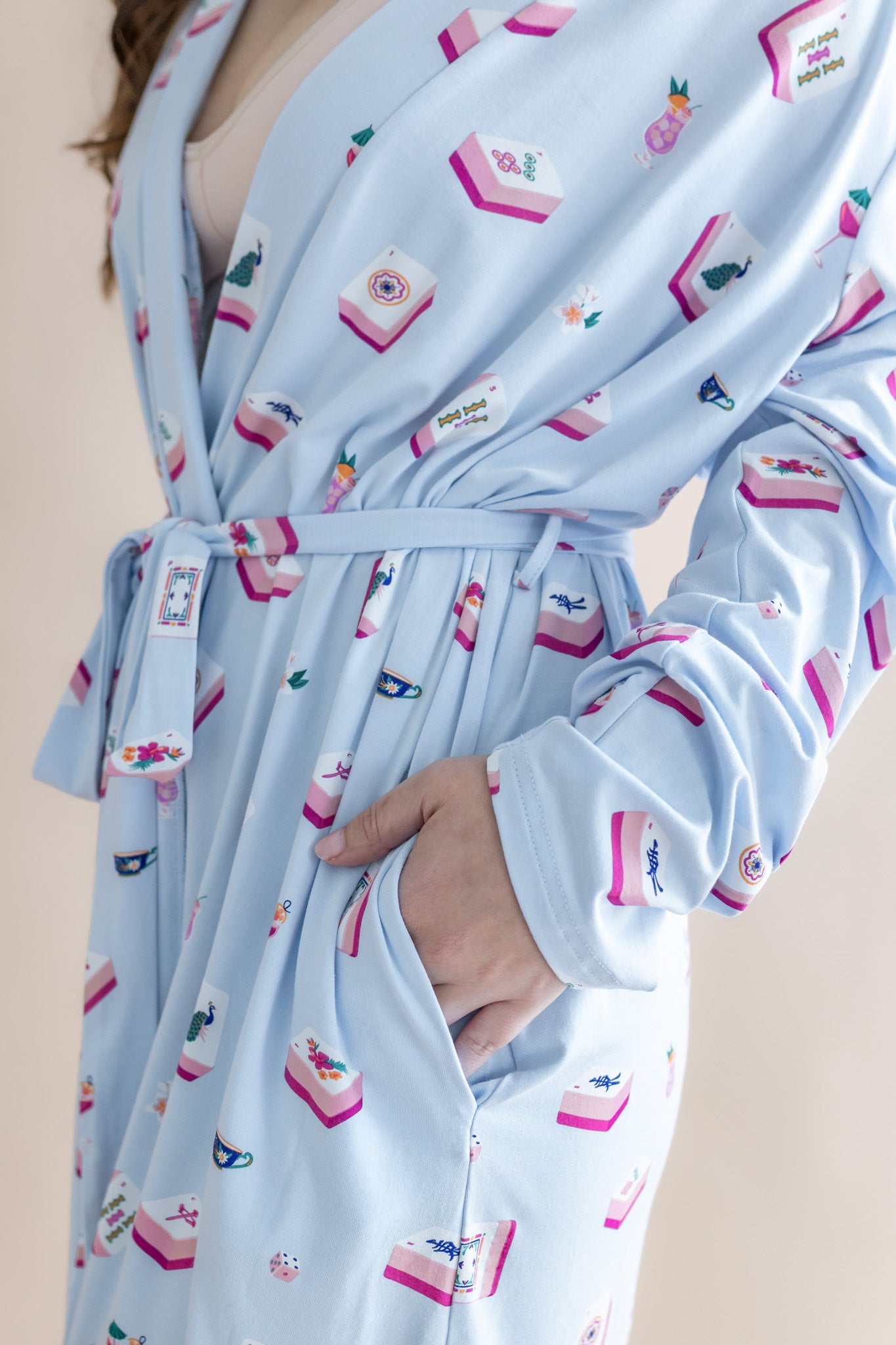 Light blue robe with colorful pattern worn by a person on a beige background