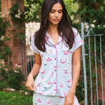 Woman wearing a light blue pajama set with pink accents outdoors.