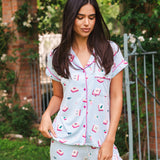 Woman wearing a light blue pajama set with pink accents outdoors.