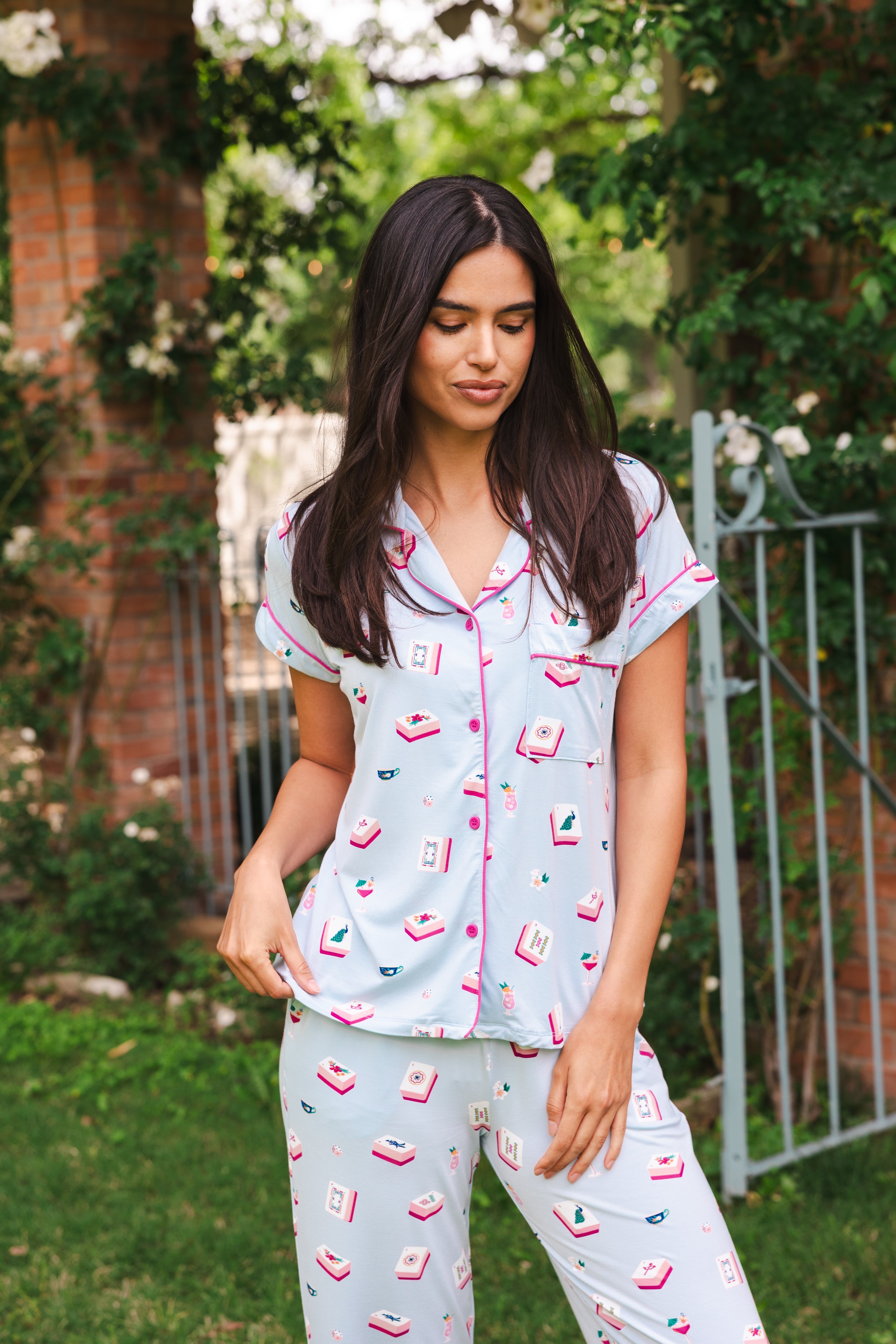 Woman wearing a light blue pajama set with pink accents outdoors.