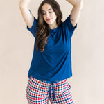 Model with arms over her head while  wearing the Women's Lounge Pants in Patriotic Gingham paired with a crew neck in Tahoe