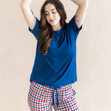 Model with arms over her head while  wearing the Women's Lounge Pants in Patriotic Gingham paired with a crew neck in Tahoe