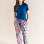 Woman modeling the Women's Lounge Pants in Patriotic Gingham paired with a crew neck in Tahoe while standing in front of a beige background 