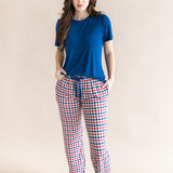Woman modeling the Women's Lounge Pants in Patriotic Gingham paired with a crew neck in Tahoe while standing in front of a beige background 