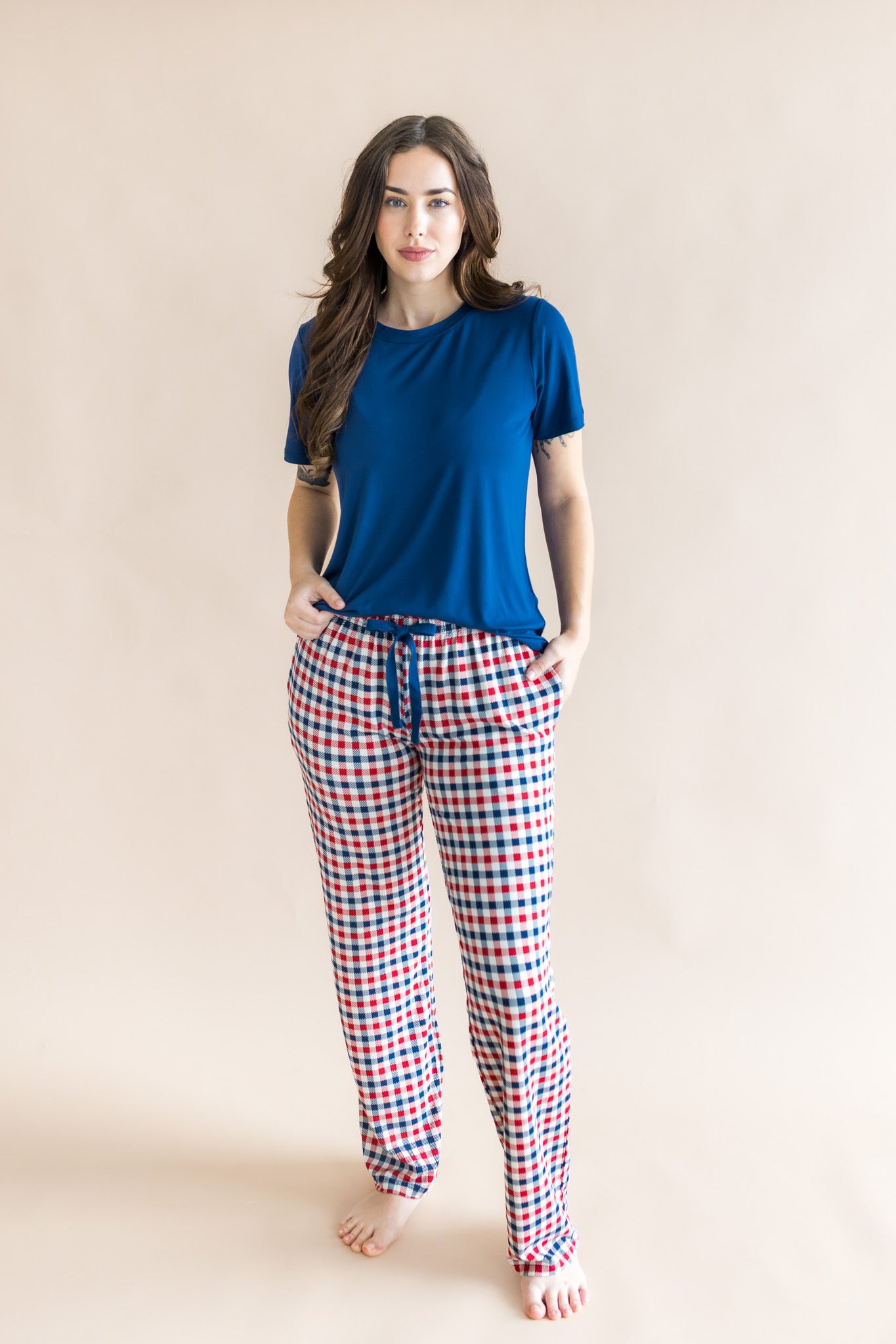 Woman modeling the Women's Lounge Pants in Patriotic Gingham paired with a crew neck in Tahoe while standing in front of a beige background 