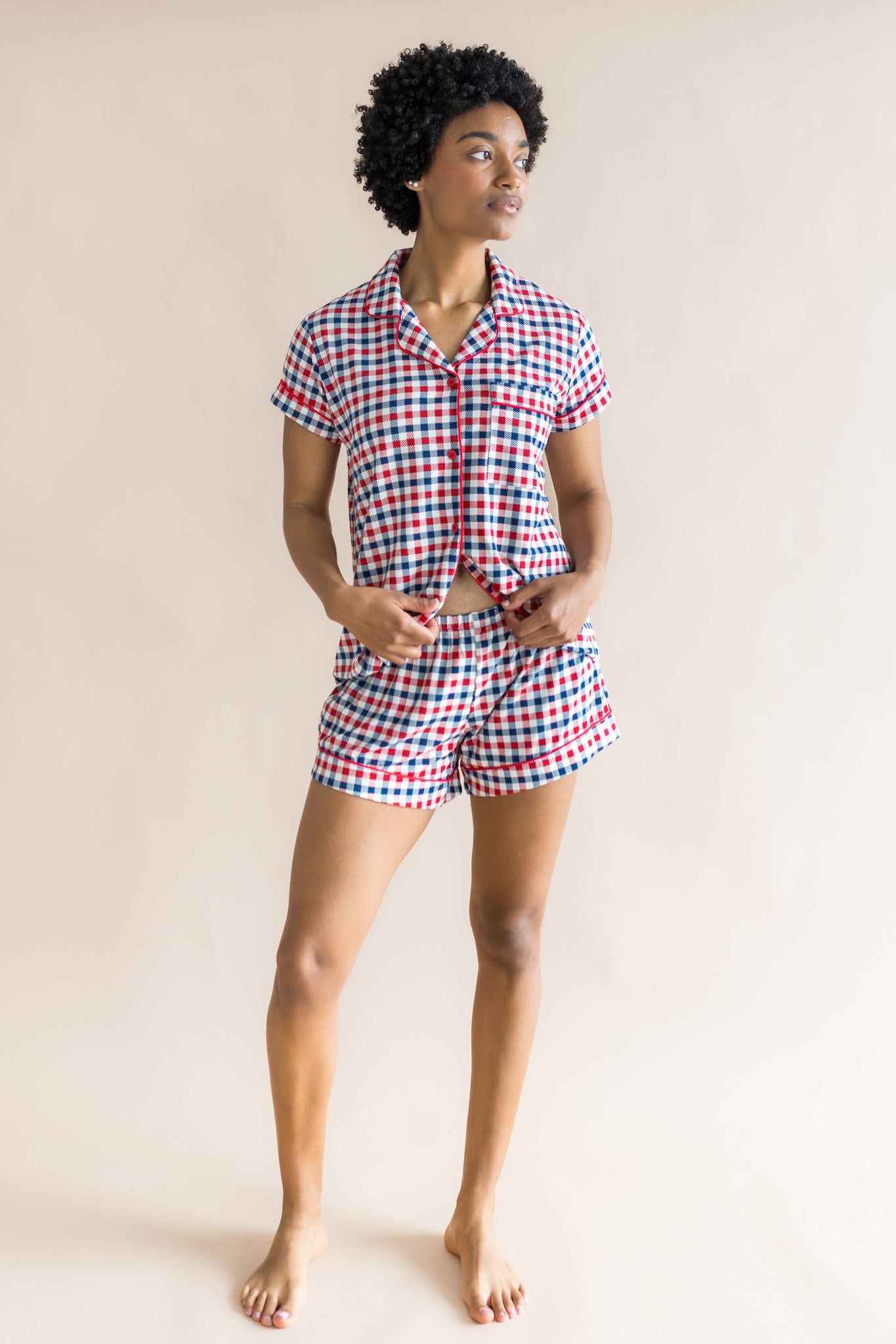 Woman looking sideways infront of a beige background while modeling the Women's Short Sleeve Pajama Set in Patriotic Gingham ::: Model is 5'9" wearing size S ///