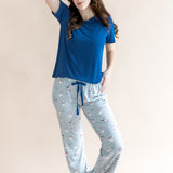 Model looking to the side with arm on her head and one knee bent while wearing the Women's Lounge Pants in Patriotic Goose paired with a crew neck in Tahoe 