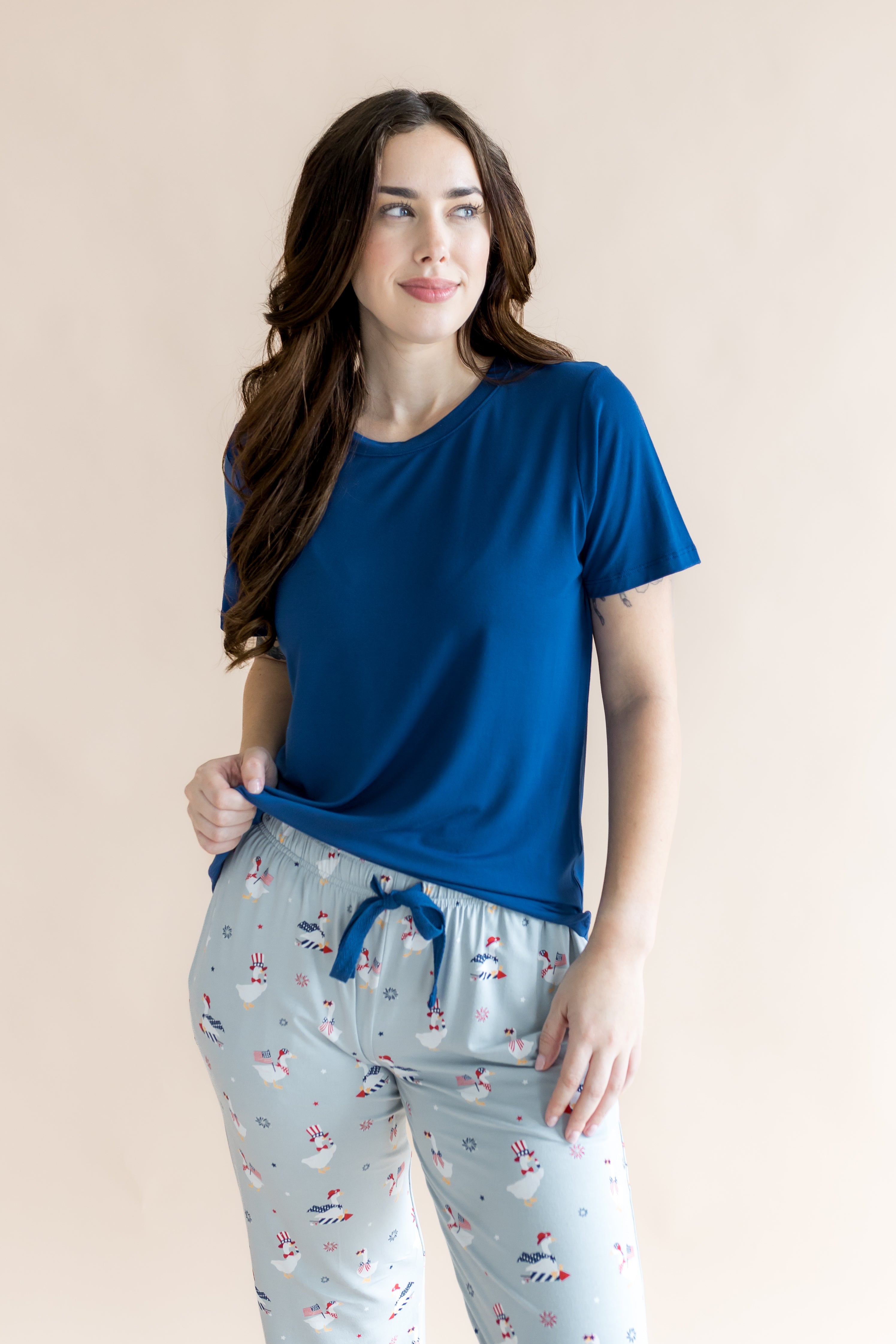 Woman looking to the side while modeling the Women's Lounge Pants in Patriotic Goose with hand on her hip 