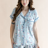 Close up of the model in front of a beige back ground while wearing the Kyte Women's Short Sleeve Pajama Set in Patriotic Goose