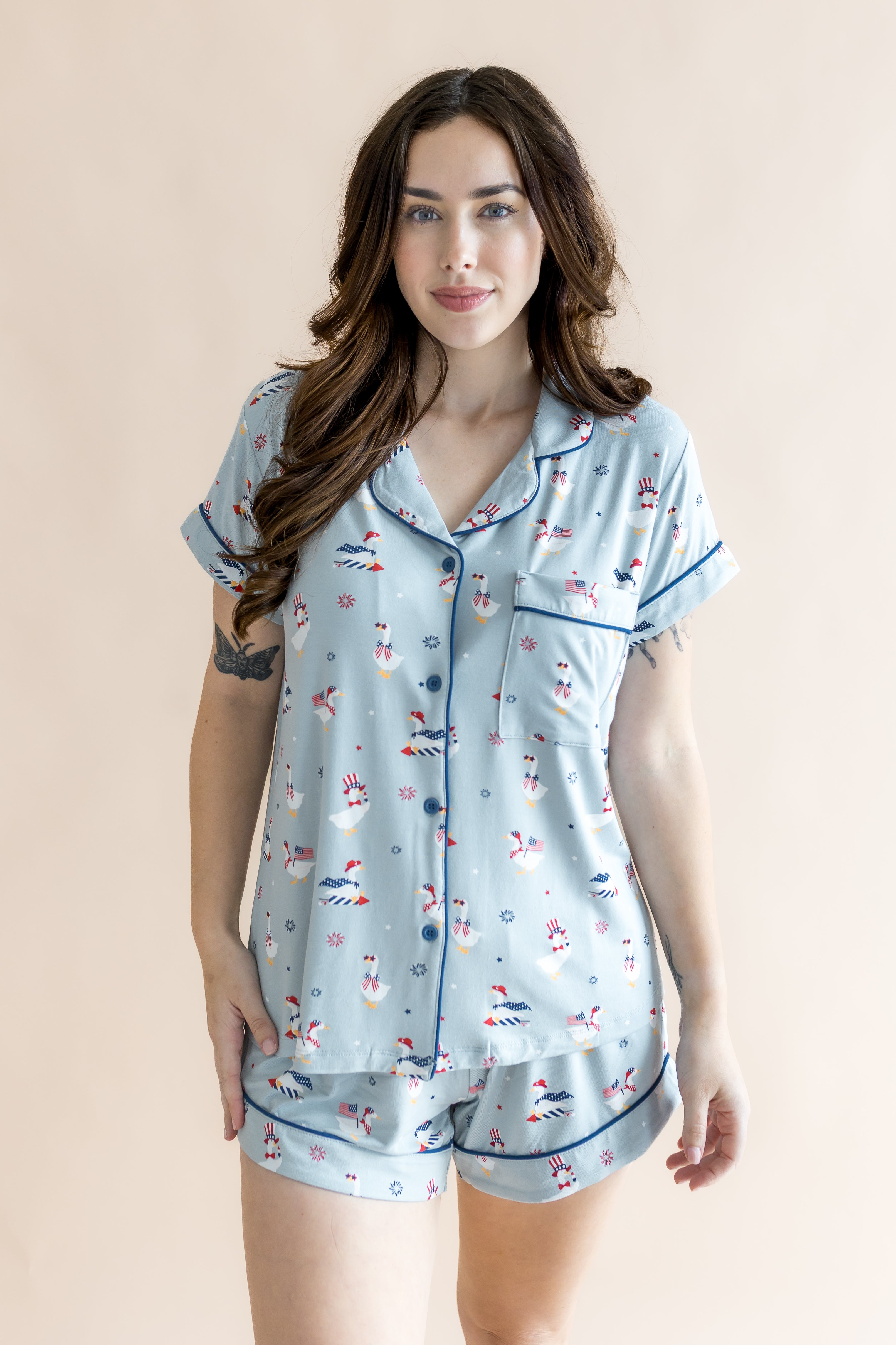 Close up of the model in front of a beige back ground while wearing the Kyte Women's Short Sleeve Pajama Set in Patriotic Goose