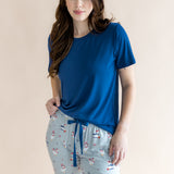 Brunette model wearing the Women's Lounge Pants in Patriotic Goose paired with a crew neck in Tahoe in front of a beige background 