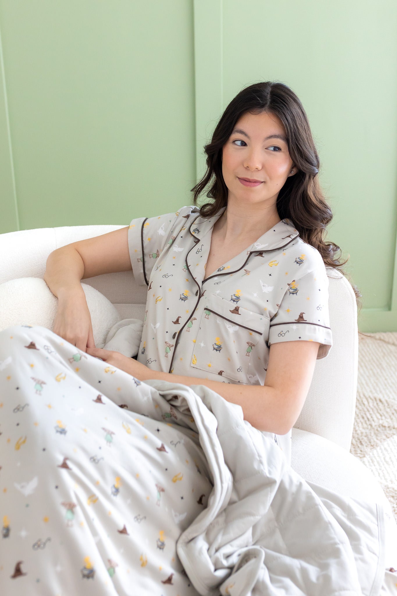 Woman looking to the side in Short Sleeve Pajama Set with the matching Throw Blanket in Starry Icon 1.0  laying on her lap 