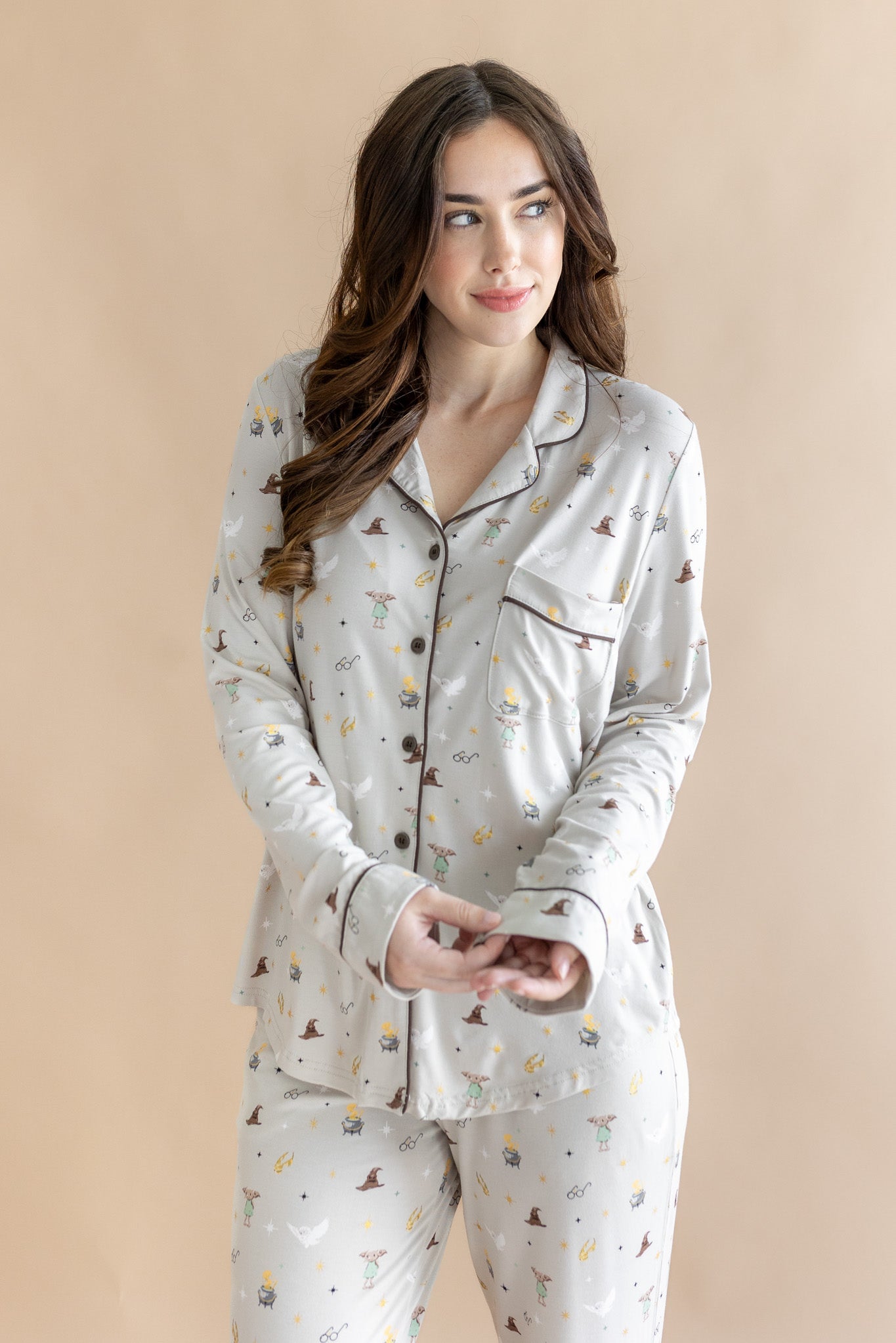 Close up of the model wearing the Long-Sleeved Women's Pajama Set in Starry Icon while she holds the wrist area of the top ::: Model is 5'7" wearing size S ///
