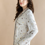 Side view of model wearing a cream Long-Sleeved Women's Pajama Set with Harry Potter prints on a beige background.