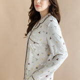 Side view of model wearing a cream Long-Sleeved Women's Pajama Set with Harry Potter prints on a beige background.