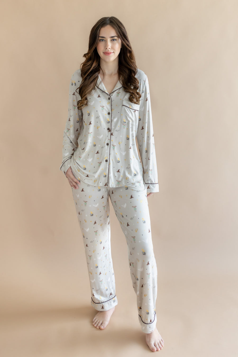 Model standing in front of a beige background while wearing the Long-Sleeved Women's Pajama Set in Starry Icon