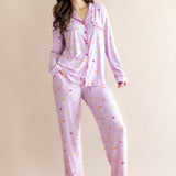 Model standing in front of a beige back ground while wearing the Long-Sleeved Women's Pajama Set in Cocktail with one leg on pointed toe

::: Model is 5'7" wearing size S ///



