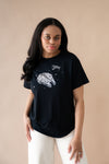 Female posing wearing the Women's Graphic Tee in Millennium Falcon™ with cream pants
::: Model is 5'6" wearing size M ///