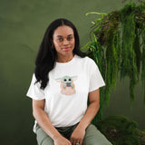 Female sitting on a tree stump with greenery on it wearing the Women's Graphic Tee in The Child™