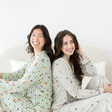 Models sitting back to back while wearing the Long Sleeve Pajama Set in Honeydukes and Starry Icon 