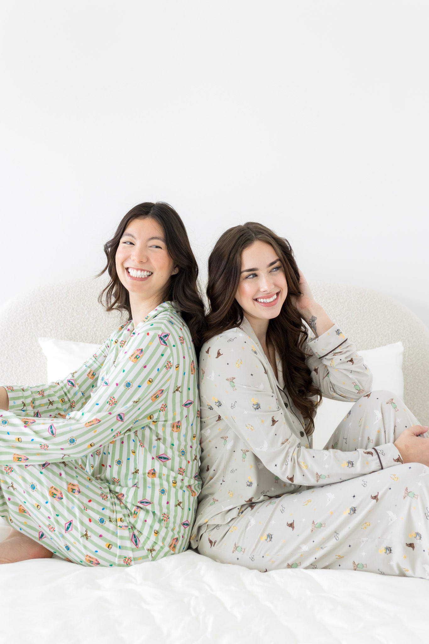 Models sitting back to back while wearing the Long Sleeve Pajama Set in Honeydukes and Starry Icon 