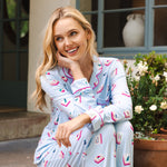 Model wearing mahjong patterned pajama set sitting on steps