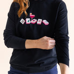 Person wearing a black sweatshirt with a mahjong design on a plain background