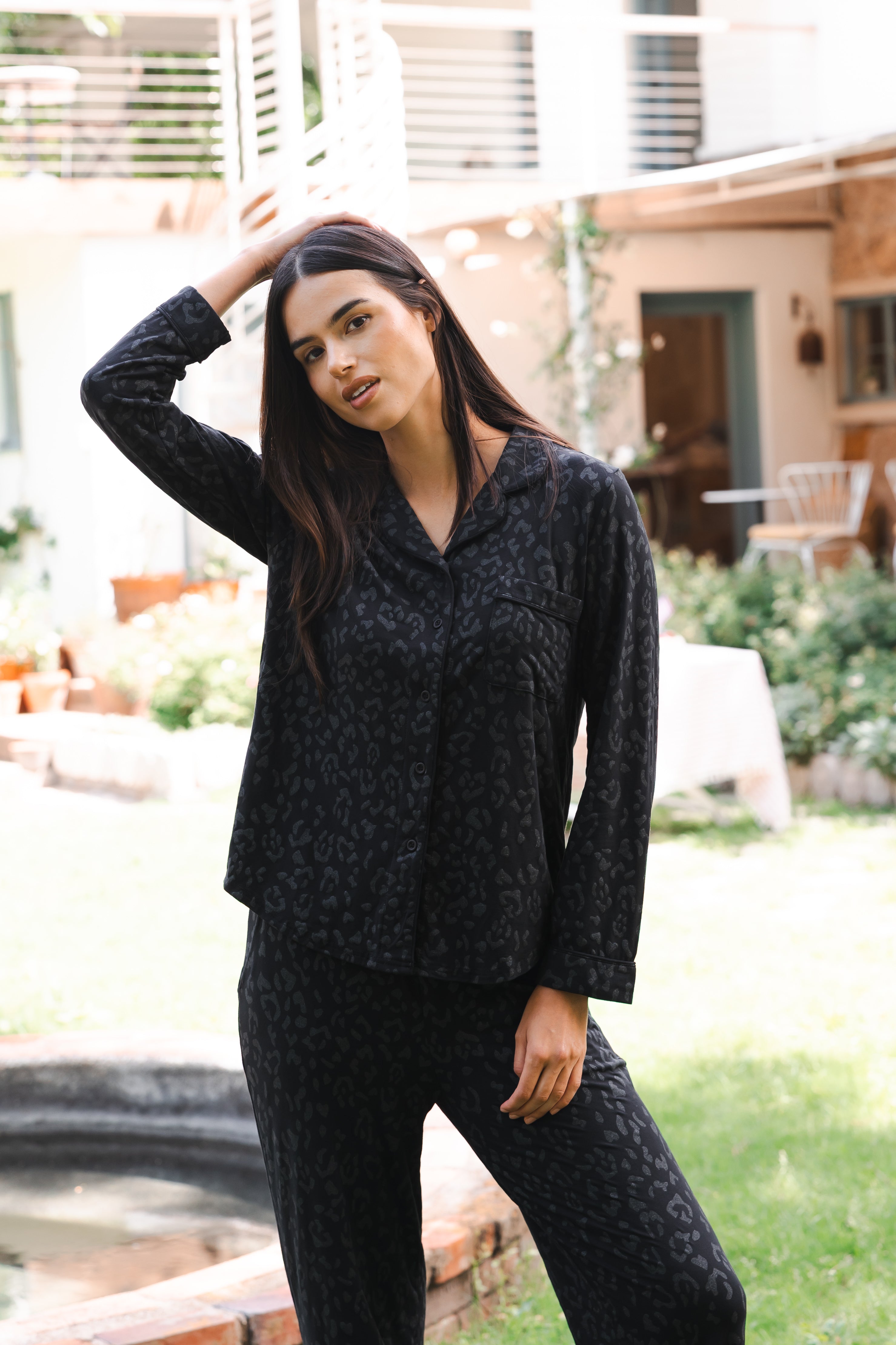 Woman wearing a black leopard patterned outfit standing outdoors. ::: Model is 5'10" wearing size S ///