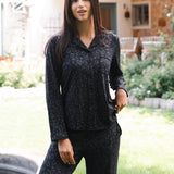 Woman wearing a black leopard patterned outfit standing outdoors in a garden. ::: Model is 5'10" wearing size S ///