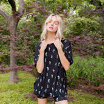 Model posing outdoors surrounded by trees wearing Women’s Biker Short Set in Midnight Wildflower print