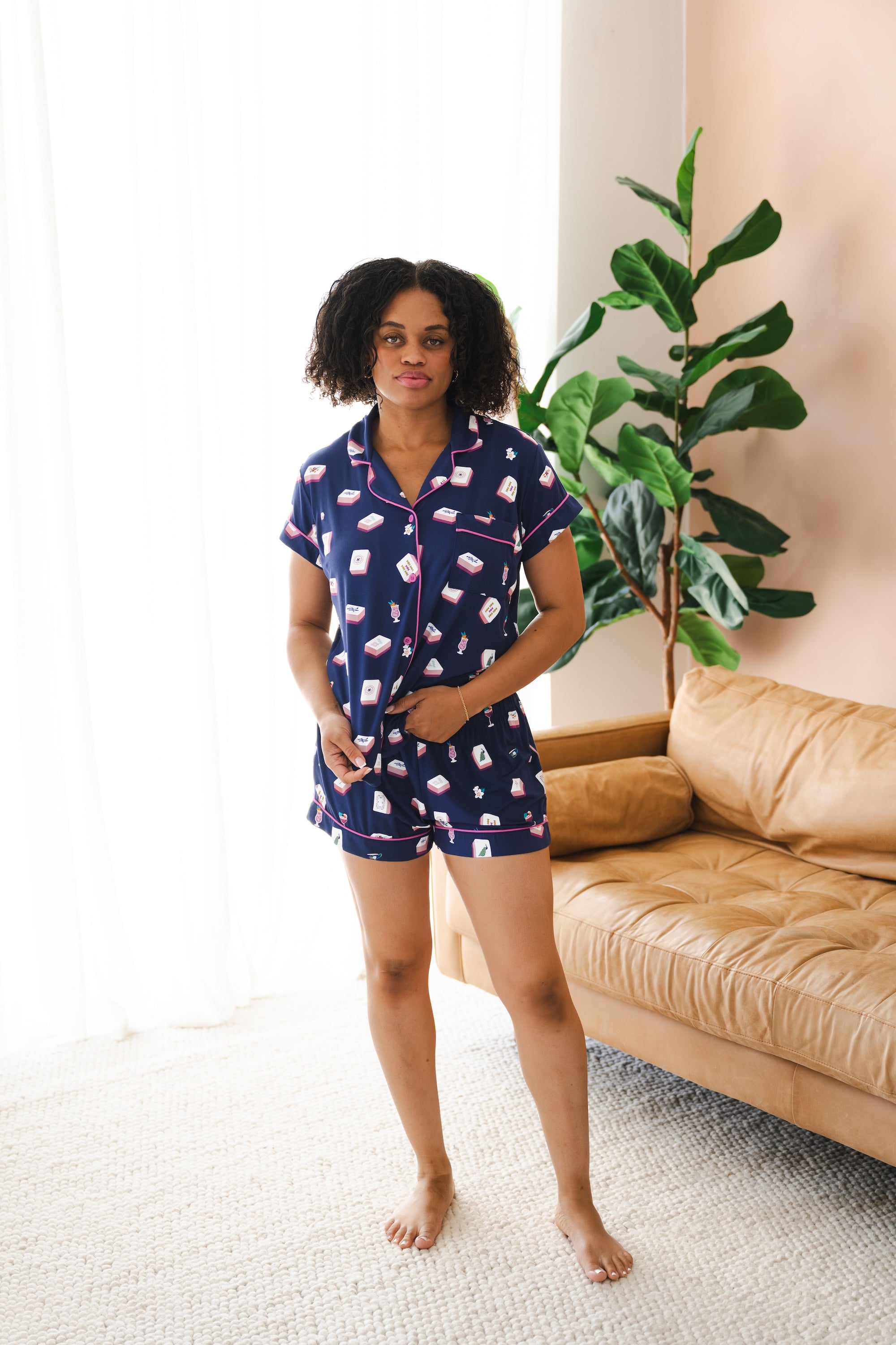 Model wearing Women's short sleeve pajama set in Navy Mahjong print in front of sofa


