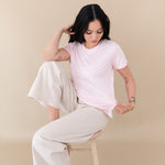 woman sitting on a stool modeling Women's Crew Neck Tee in Sakura 
