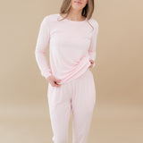 Woman modeling Women's Jogger Pajama Set in Sakura slightly lifting top to show elastic band of jogger pant