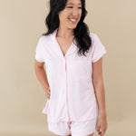 Woman modeling Women’s Short Sleeve Pajama Set in Sakura with Cloud Trim looking off to side