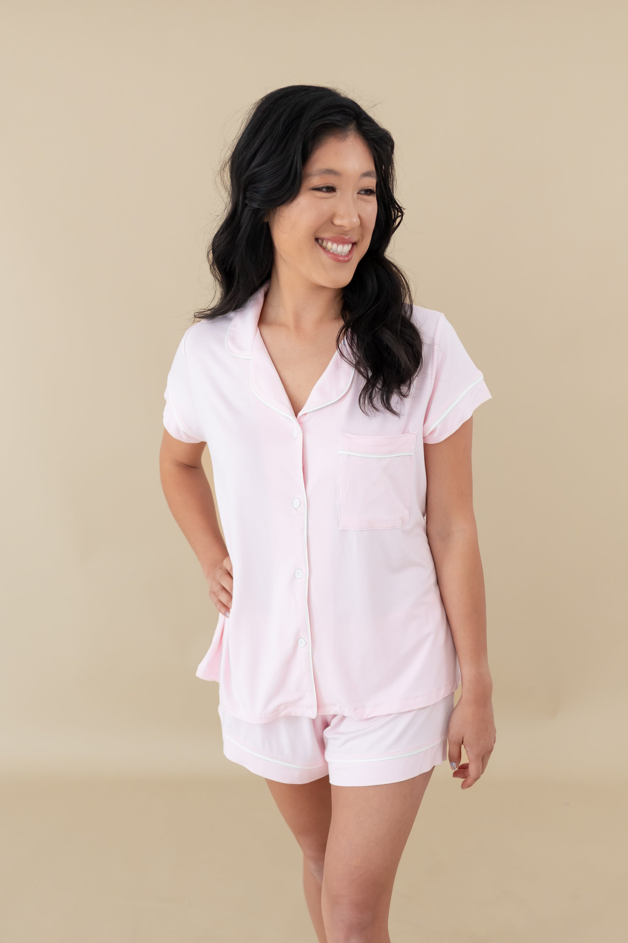 Woman modeling Women’s Short Sleeve Pajama Set in Sakura with Cloud Trim looking off to side
