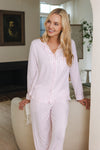 Woman wearing pink stripe pajamas standing in a living room. ::: Model is 5'9" wearing size XS ///
