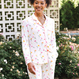 Woman wearing a tulip pajama set standing outdoors with greenery in the background