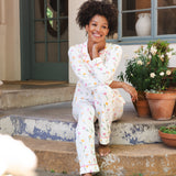 Woman in pajamas sitting on a porch with potted plants