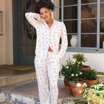 Woman in a white tulip pajama set standing on a porch with potted plants. ::: Model is 5'9"" wearing size S ///