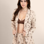 Female modeling the Long-Sleeved Women's Pajama Set in Classic Cowboy with the shirt unbuttoned showing the espresso cross front bralette on underneath