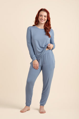Woman wearing a blue pajama set on a beige background