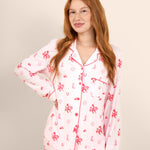 Woman wearing a pink and white disco cowgirl pajama set against a plain background