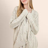 Woman modeling oat colored cable knit cardigan over a silk dress  ::: Model is 5'7" wearing size S ///