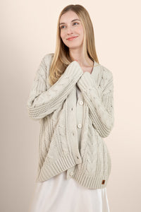 Woman modeling oat colored cable knit cardigan over a silk dress  ::: Model is 5'7" wearing size S ///