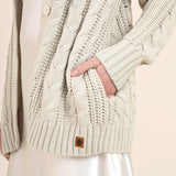 Close up of oat colored cable knit cardigan