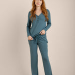 Woman wearing teal pajamas on a beige background