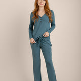 Woman wearing teal pajamas on a beige background