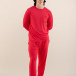 Person wearing a red pajama set on a beige background