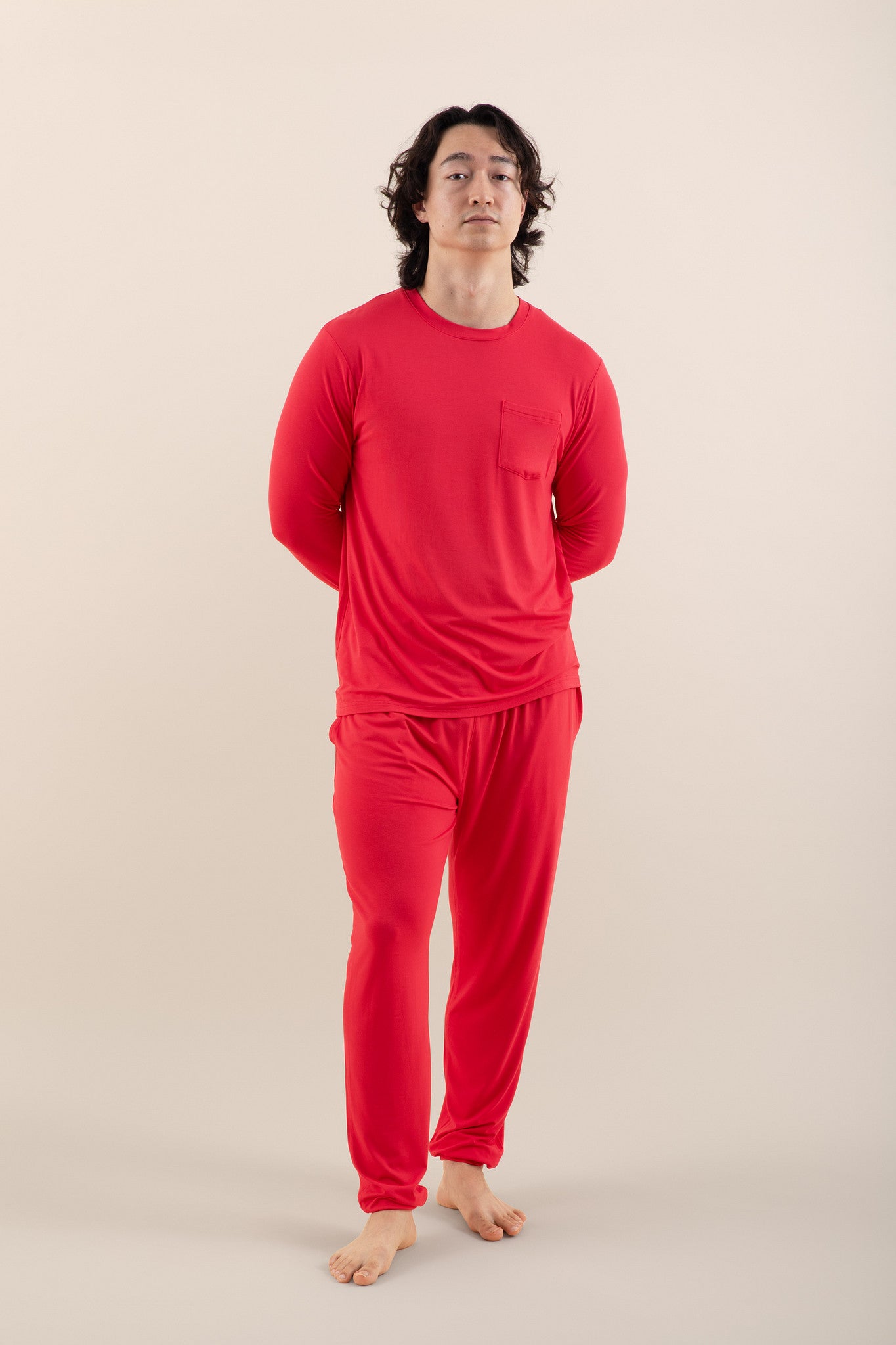 Person wearing a red pajama set on a beige background