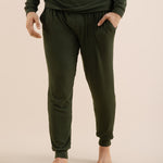 Person wearing green jogger pants on a beige background
